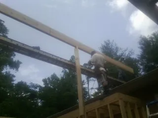 Carpenter setting a ridge beam over a new addition frame — Ice Dam Removal by Roofing Brothers in Kaneville