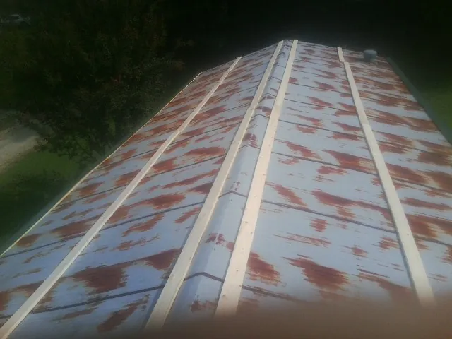 Rusted metal roof panels with new wood purlins before replacement — Storm Damage Roof Repair in Kaneville by Roofing Brothers