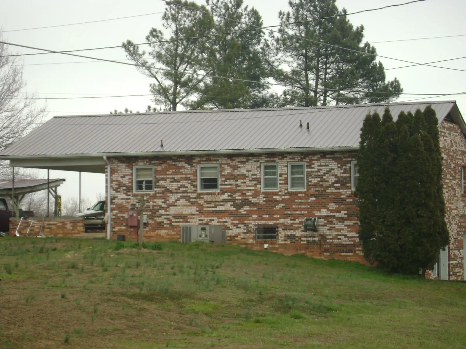 Gray metal roof on a brick split level home with a carport in Kaneville