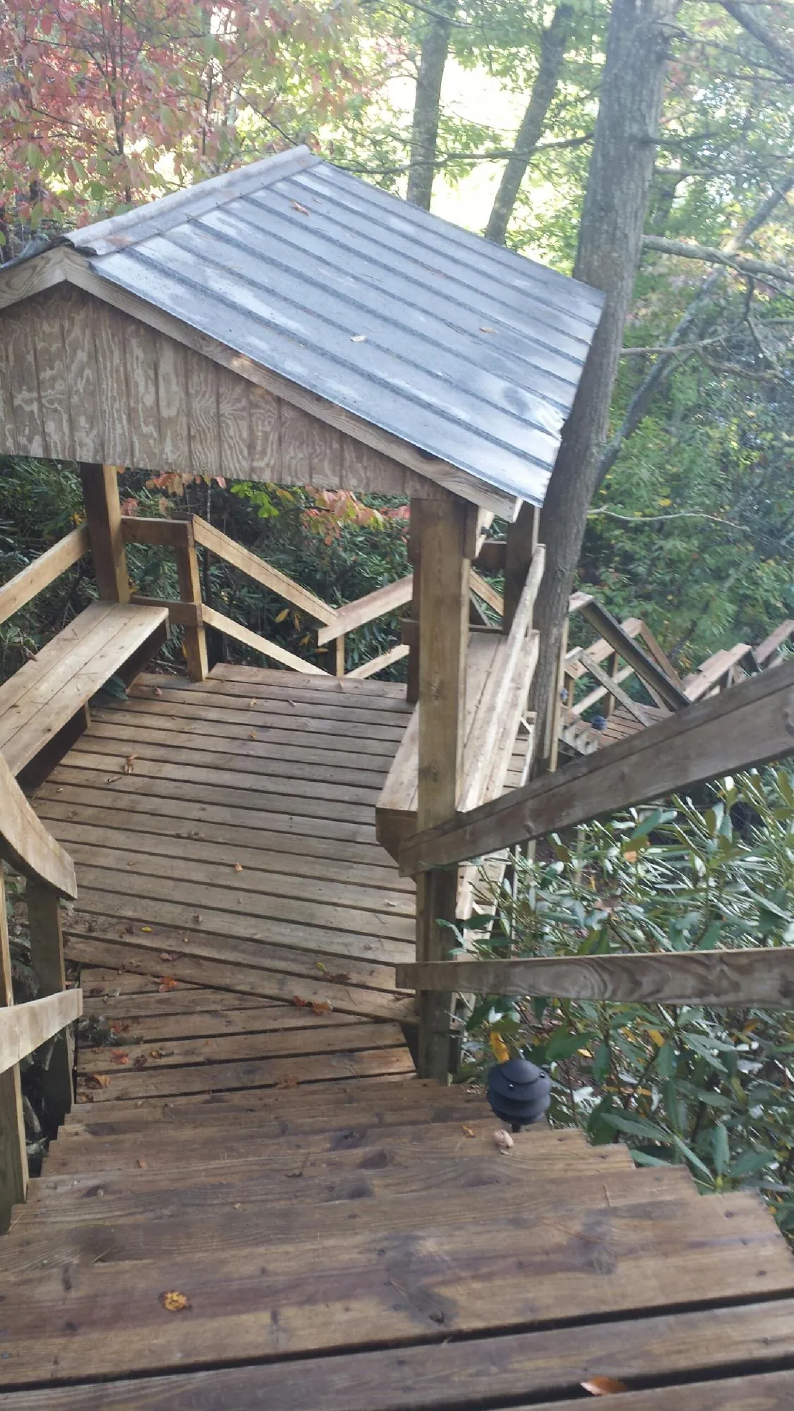 Metal roofed shelter over wooden steps on a wooded walkway — Skylight Repair & Installation work by our crew in Kaneville