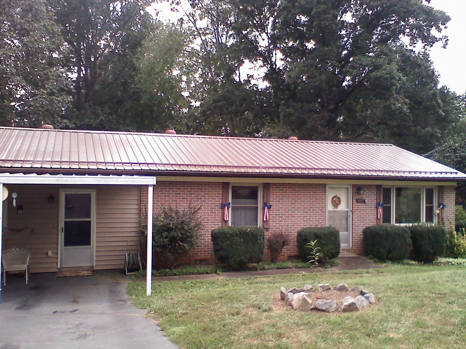 Bronze metal roof and carport on a brick ranch home — Roof Repair work by our crew in Kaneville