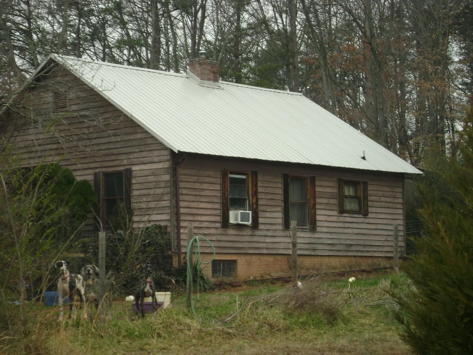 White metal roof on an old wood sided farmhouse, from a Metal Roof Installation job in Kaneville